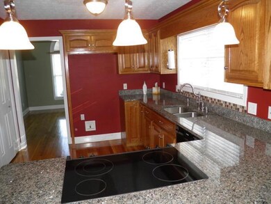 From this angle, you can see the granite countertops, cooktop, and tile backsplash at the sink.   The formal dining room is through the door on the left. 