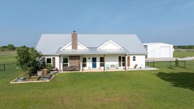 Back of house featuring a chimney, an outbuilding,