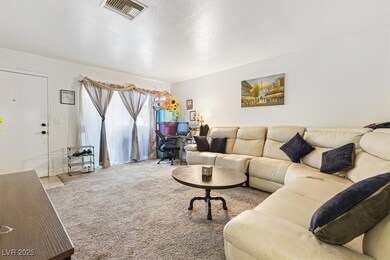 Carpeted living area with visible vents