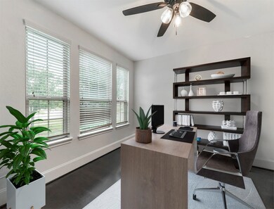 Quietly tucked away in the front of the home is the office featuring French doors, wood floors, high ceilings, a ceiling fan, and large windows that let in plenty of natural light.