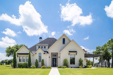 Modern farmhouse style home with board and batten siding, a front lawn, brick siding, and a standing seam roof