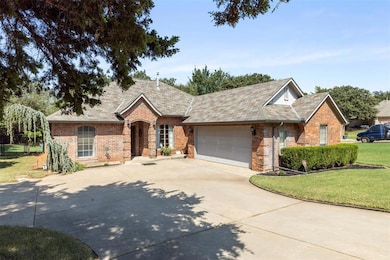View of front of property featuring a shingled roof, brick siding, concrete driveway, a front yard, and an attached garage