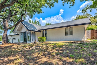 Ranch-style home featuring brick siding, a garage, and a shingled roof