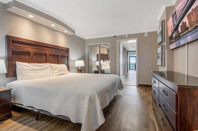 Bedroom with ornamental molding, wood finished floors, and recessed lighting