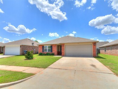Single story home featuring a garage, brick siding, a front lawn, and driveway