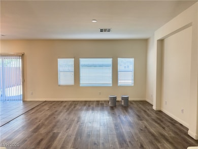 Empty room featuring dark wood-style floors and ba
