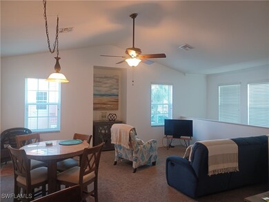 Living area with vaulted ceiling, carpet, and a ce
