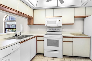 Kitchen featuring white appliances, sink, white ca