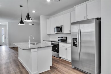 Kitchen with dark wood-style flooring, appliances 