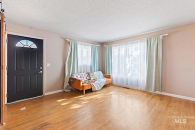 Foyer entrance with light wood-type flooring and a textured ceiling