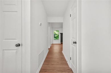 Hallway featuring light wood-style floors and baseboards