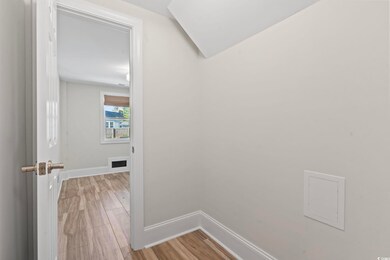 Hallway featuring light wood finished floors and b