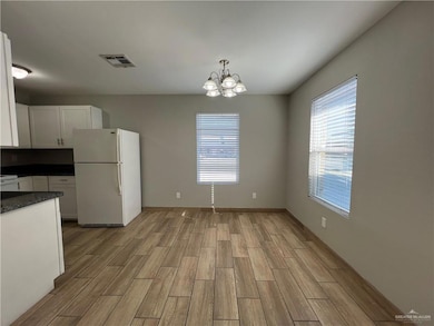 Unfurnished dining area featuring light wood-style flooring and a chandelier