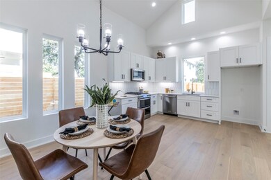 Dining area with high vaulted ceiling, plenty of natural light, light wood-style floors, a chandelier, and recessed lighting