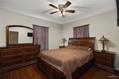 Bedroom with dark wood-type flooring, baseboards, and ceiling fan