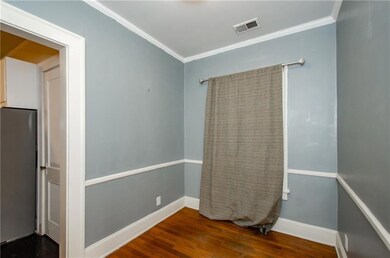 Empty room with ornamental molding and dark wood finished floors