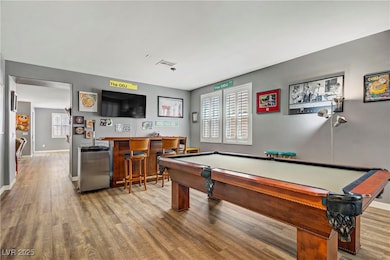 Playroom featuring a community bar, wood finished floors, plenty of natural light, and pool table