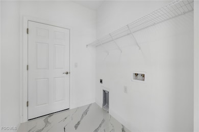 Laundry room featuring marble look tile flooring, washer hookup, and hookup for an electric dryer