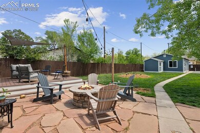 View of patio with an outdoor fire pit, an outdoor structure, and a deck