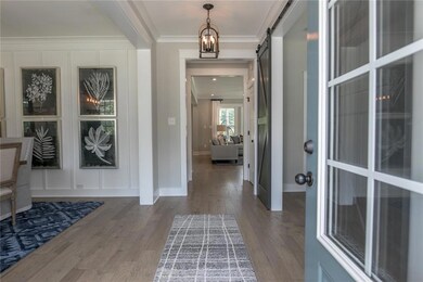 The first floor offers a large dining room with board and batten trim. The office has a closet and barn doors. Hardwoods throughout most of the downstairs. Spacious first floor guest suite. DESIGNER Kitchen with huge quartz island and walk-in pantry.