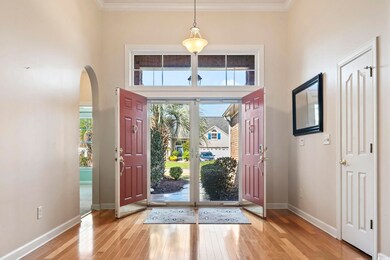 Foyer featuring a towering ceiling, light hardwood