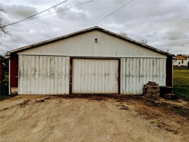 Street view of 3 car garage with concrete floor.