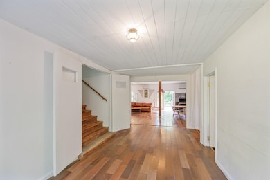 Hallway with wood-type flooring, wood ceiling, and stairway