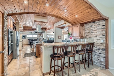 Kitchen with wooden ceiling, stone tile floors, a