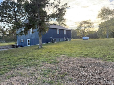 View of property exterior with a lawn and view of scattered trees