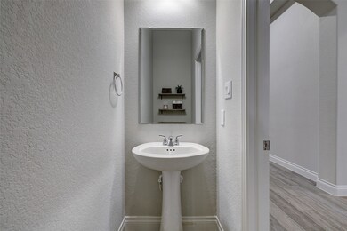 Private water room features: Pedestal porcelain sink, modern frameless mirror and wood tiled flooring