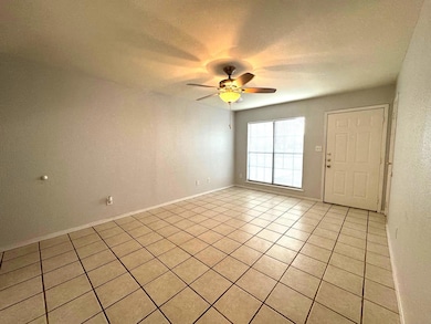 Spare room featuring light tile patterned floors and ceiling fan