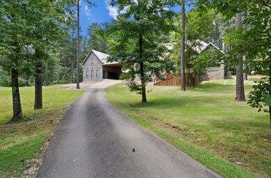 View of front of house featuring asphalt driveway, a front lawn, and stone siding
