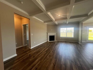 Unfurnished living room with beamed ceiling, dark wood-style floors, coffered ceiling, a fireplace, and baseboards