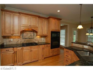 Kitchen. Kitchen with custom cabinets, granite countertops, built in microwave, built in oven, gas cook top and tiled backsplash.