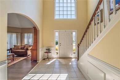 Foyer entrance featuring arched walkways, light ti