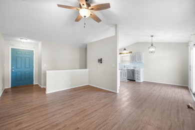 Unfurnished living room with light wood finished floors, vaulted ceiling, and ceiling fan