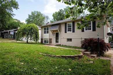 Raised ranch featuring a front lawn and a chimney