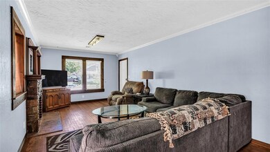 Living room featuring ornamental molding, dark har