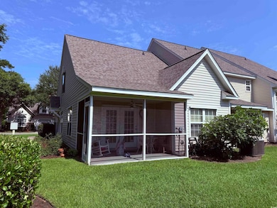 Rear view of property with roof with shingles, a sunroom, a lawn, and a ceiling fan