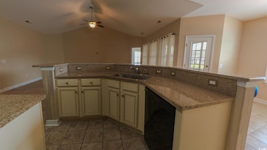 Kitchen with a sink, cream cabinets, black dishwasher, light tile patterned floors, and ceiling fan