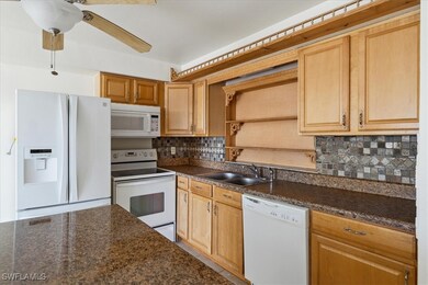 Kitchen with decorative backsplash, white applianc