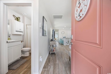 Hall featuring wood finished floors, baseboards, and recessed lighting