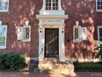 Doorway to property featuring brick siding
