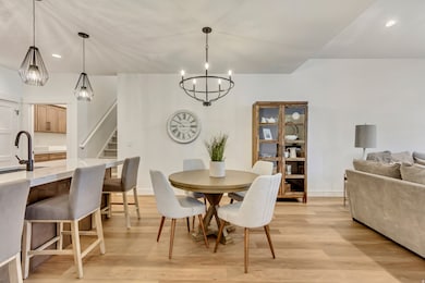 Dining room with recessed lighting, light wood finished floors, stairway, and a chandelier