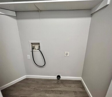 Washroom featuring dark wood-type flooring, hookup for a washing machine, and hookup for an electric dryer