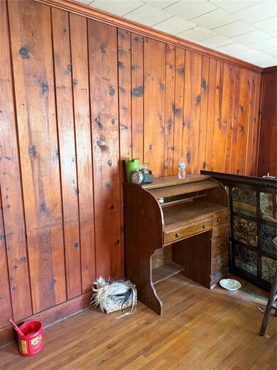 Unfurnished office with hardwood / wood-style floors and wooden walls