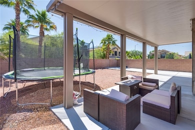 Fenced backyard with a trampoline, a patio, and a