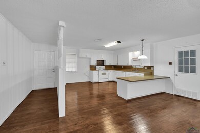 Kitchen featuring kitchen peninsula, sink, white r
