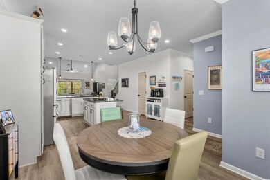 Dining area with a notable chandelier, light wood-