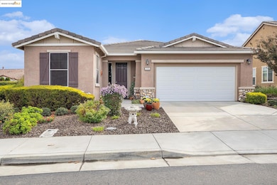 Ranch-style home with stone siding, stucco siding, concrete driveway, a tiled roof, and a garage